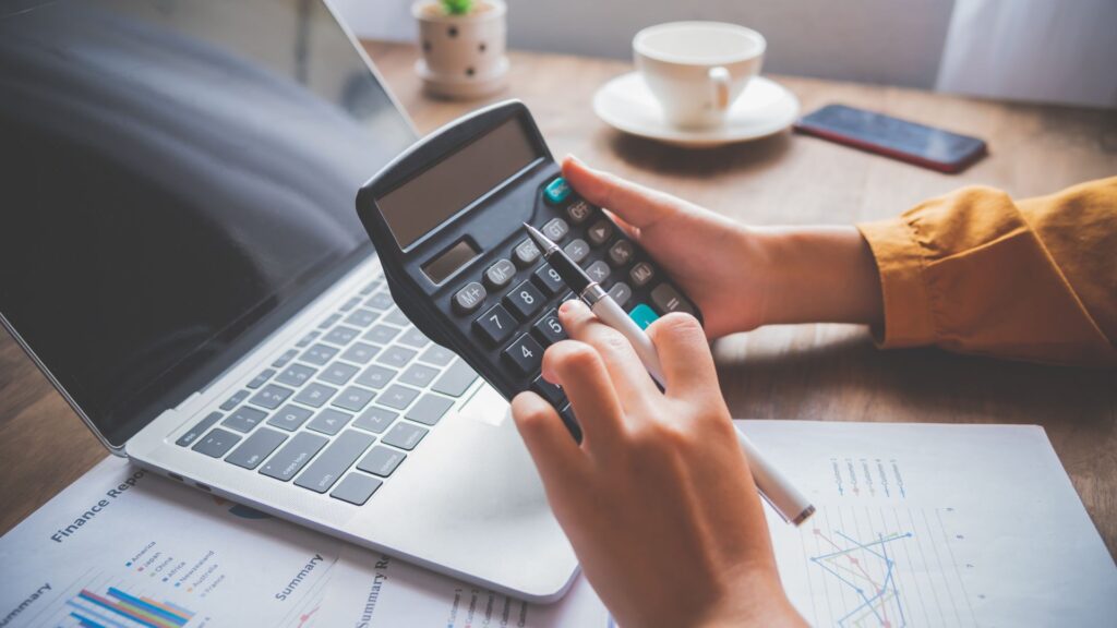 Contractor reviewing government certified payroll documents and wage reports on a construction site office desk.