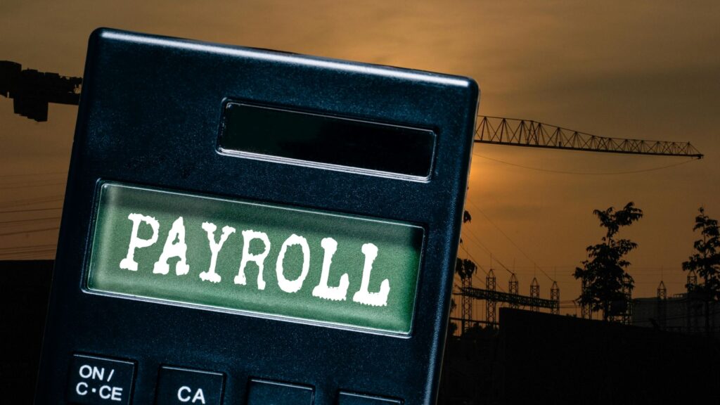 Construction team reviewing certified construction payroll documents on a job site to ensure prevailing wage compliance.